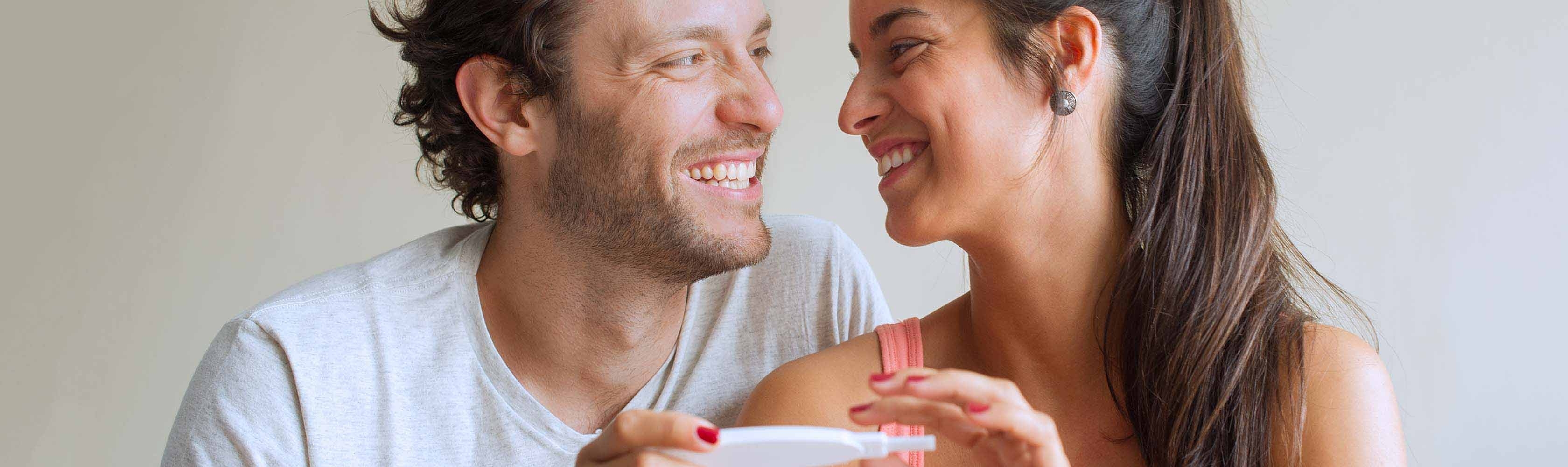 Schwanger werden – Glückliches Paar mit Schwangerschaftstest