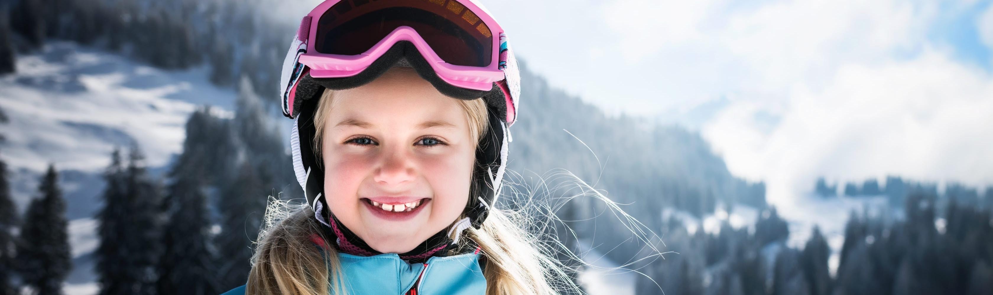 Une fille avec un casque de ski est prête pour faire la descente en luge