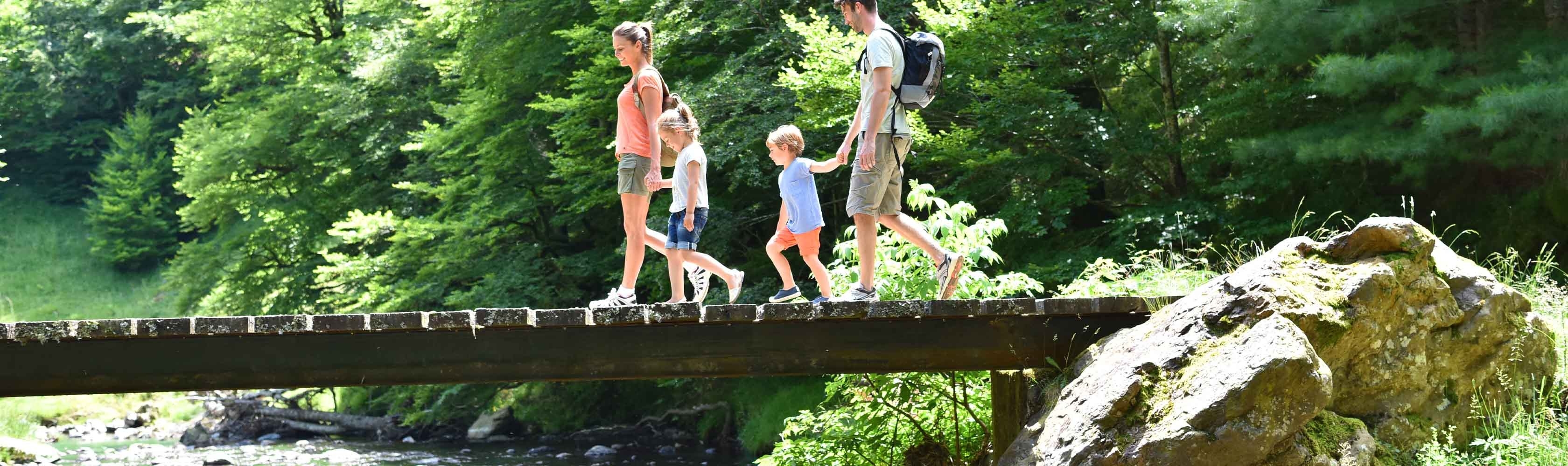 Une famille randonne au bord d'une rivière