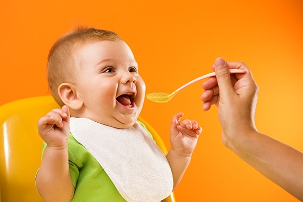 Un bébé se réjouit de manger sa bouillie.