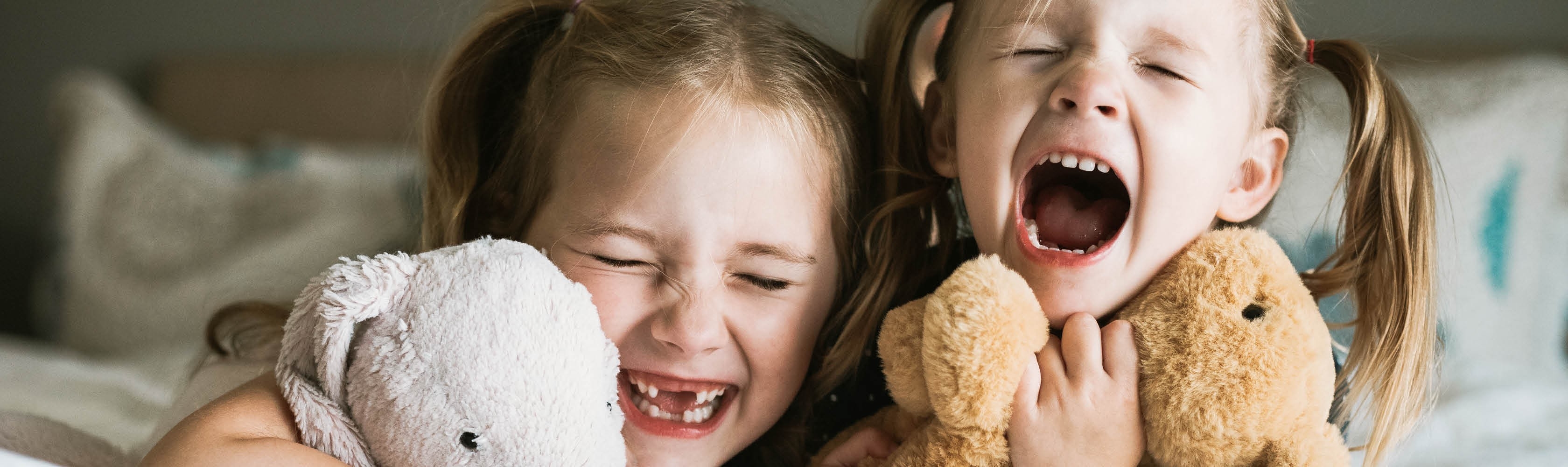 Deux filles rient. Conclure une assurance pour soins dentaires en vaut la peine, surtout pour les enfants.