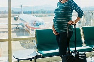 Una donna incinta attende il suo aereo in aeroporto