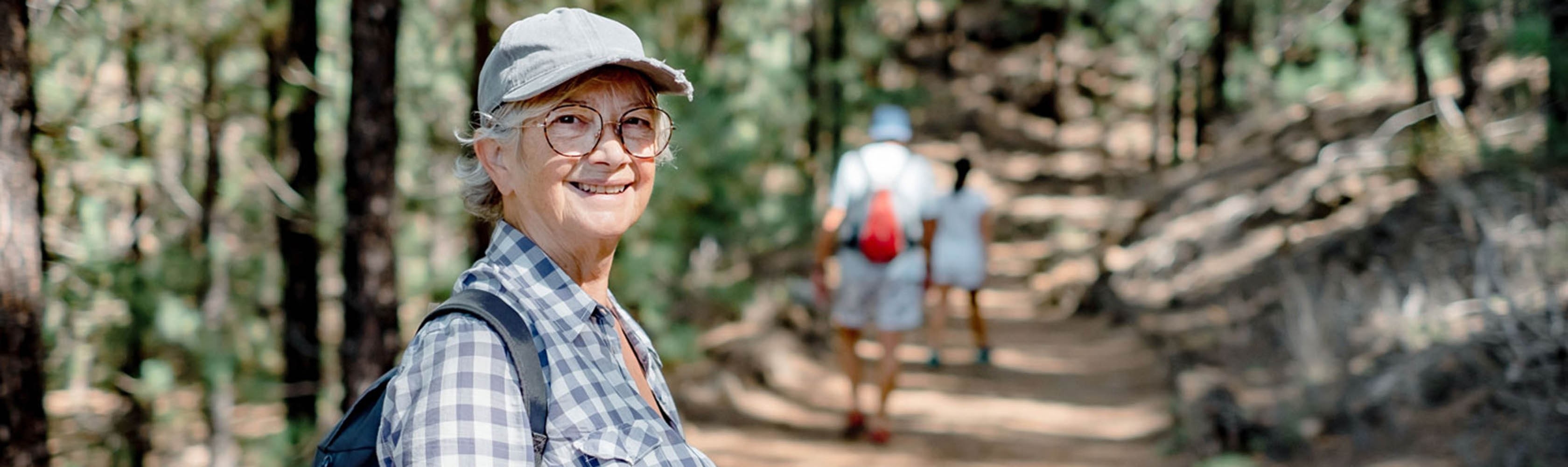 Una donna anziana si gode un'escursione con gli amici nella foresta